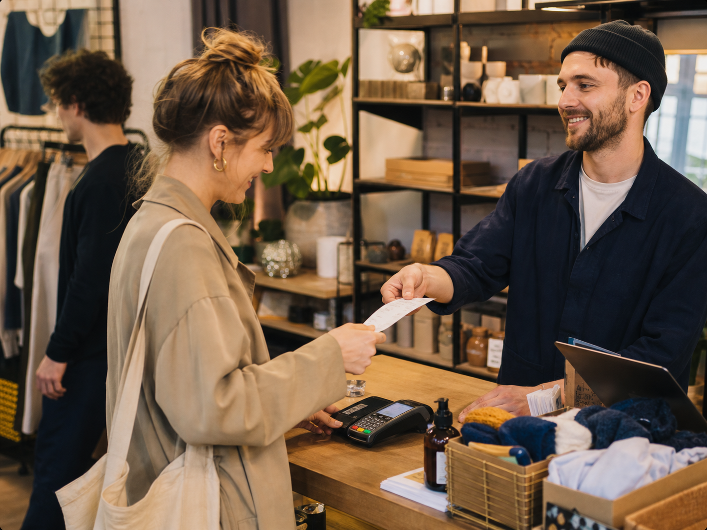 A shop owner handing a receipt to a customer at checkout.